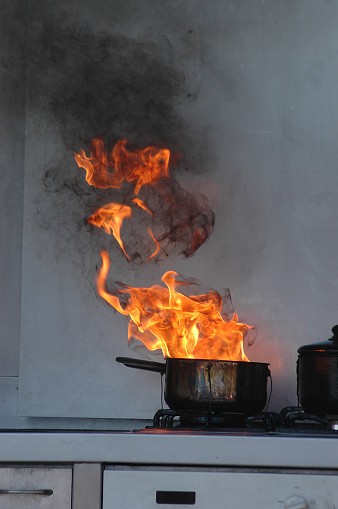 flames from burning oil on a kitchen stove