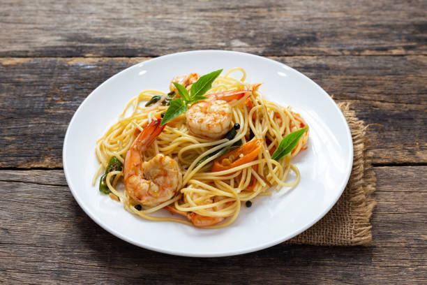 istock Spaghetti with spicy fried shrimp on a wooden table 1167555730