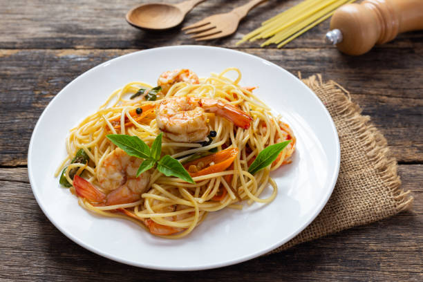 istock Spaghetti with spicy fried shrimp on a wooden table 1167555823