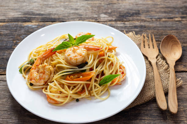 istock Spaghetti with spicy fried shrimp on a wooden table 1167555827