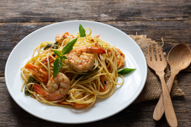 istock Spaghetti with spicy fried shrimp on a wooden table 1167555829