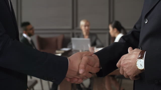 Executives Shaking Hands during Corporate Meeting