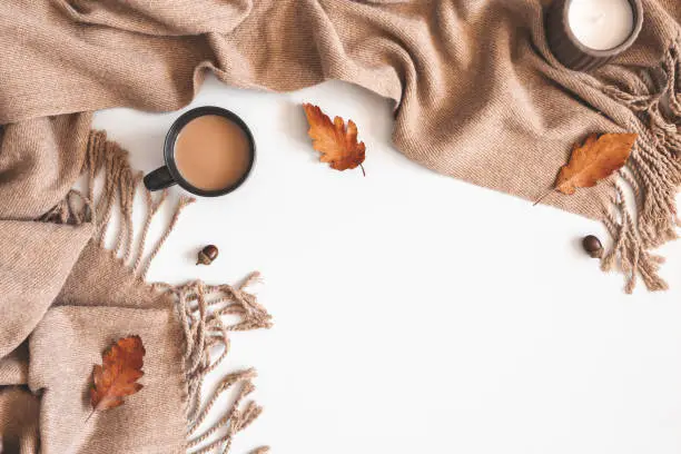 Photo of Autumn composition. Cup of coffee, plaid, autumn leaves on white background. Flat lay, top view, copy space