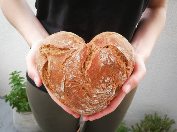 Woman with bread in heart shape in her hands