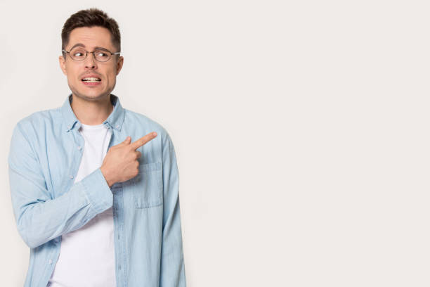 istock Worried man in glasses pointing aside at empty copy space 1167560976