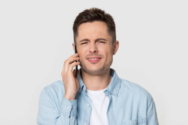 headshot studio portret zirytowany niezadowolony facet mówi przez telefon komórkowy - rudeness blah customer boredom zdjęcia i obrazy z banku zdjęć