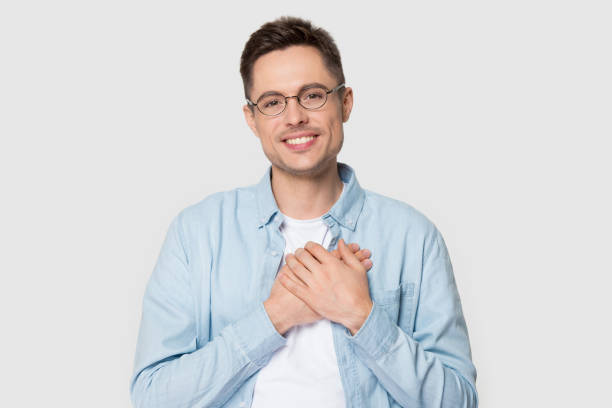 istock Young man in glasses holds hands on chest feels gratitude 1167561014