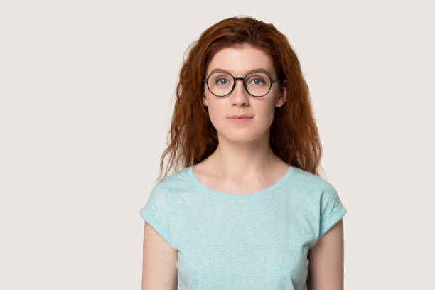 istock Serious red-headed woman in glasses over grey background 1167561640