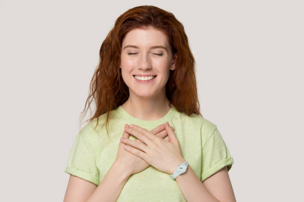 istock Female closing her eyes holds hands on chest feels gratitude 1167561666