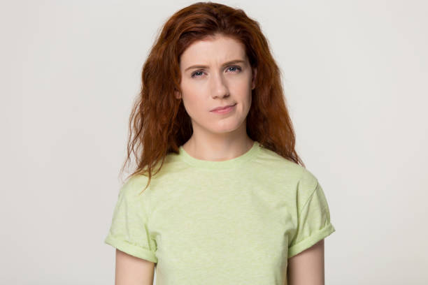 istock Redhead woman feels confused suspicious pose over grey studio background 1167561687