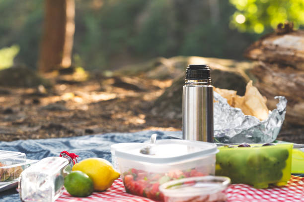 A Fresh and Colorful Spring Picnic Scene Featuring Sliced Bread, Brie Cheese, Avocado, Juicy Fruits Like Oranges and Bananas, Refreshing Citrus Water, and a Beautiful Bouquet of Lily of the Valley Flowers.
