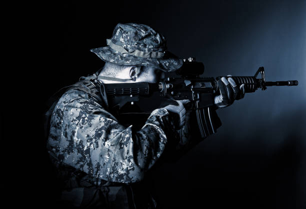 istock Side View Of Man Holding Gun In Dark At Night 1167567018