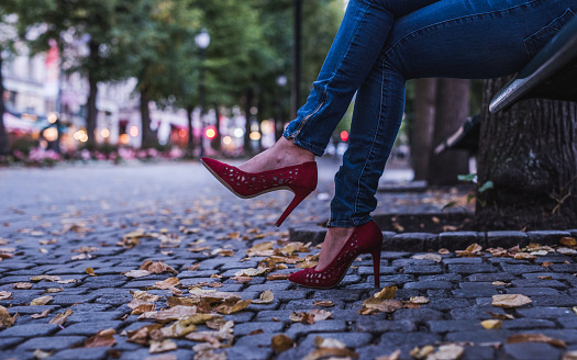 Close up of red high heels in park at autumn.