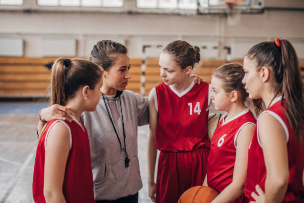 istock Coach standing with basketball team 1167577773