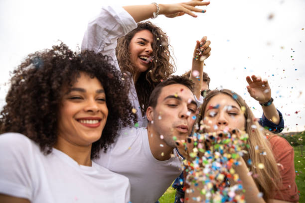 istock Friends having fun outdoors in a park playing with confetti 1167577908