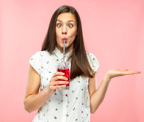 istock Playful Young Adult Squinting for Fun while Drinking Ice Tea 1167579320