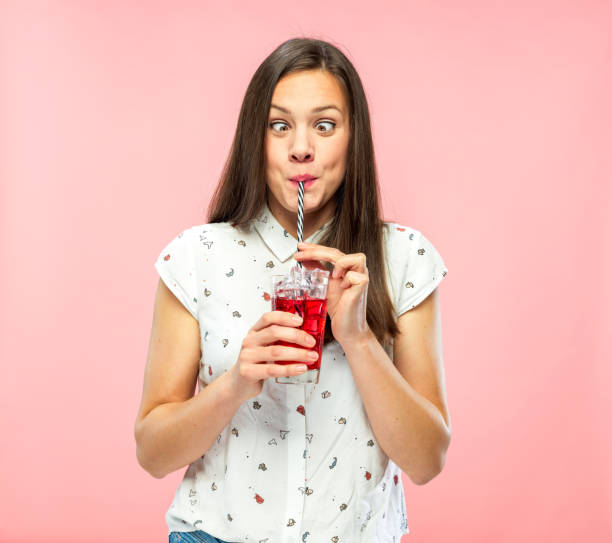 istock Playful Young Adult Squinting for Fun while Drinking Ice Tea 1167579321