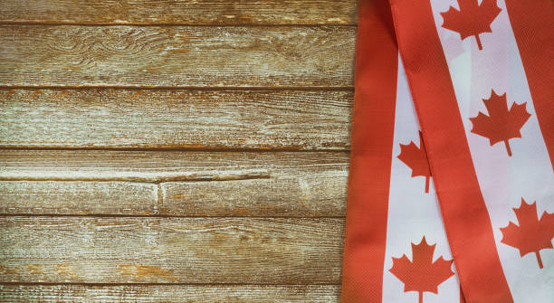 kanadische rot-weiße flagge vor dunklen rustikalen hintergrund für canada day feier und nationale feiertage - canada day fotos stock-fotos und bilder