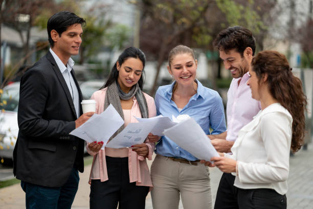 istock Successful group of business people checking some documents outside laughing and smiling 1167579906