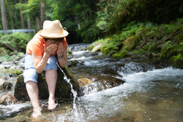 istock Senior woman cooling down in cold river 1167580028