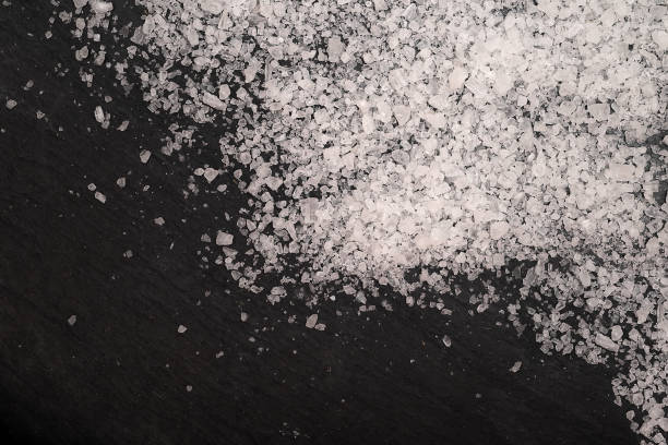 istock Spilled white sea salt isolated black background. 1167581207