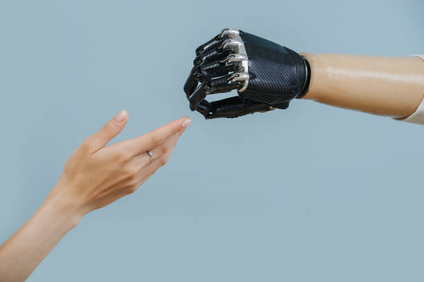 istock artificial limb and female hand stretch to each other 1167582127