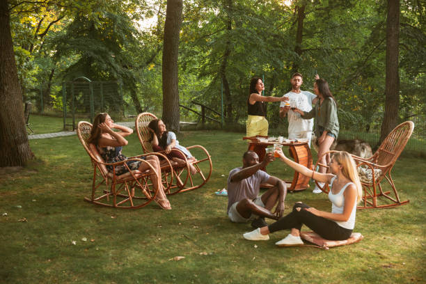 istock Happy friends eating and drinking beers at barbecue dinner on sunset time 1167583679
