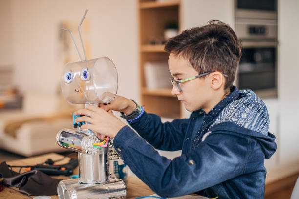 istock Boy making robot toy of recycling material 1167584788