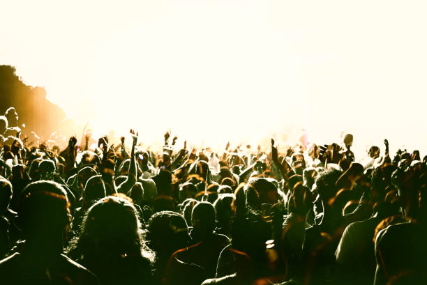 Concert crowd with copy space with vintage colours. Taken at a concert in the forest at nighttime. A large group of unrecognisable people.