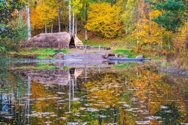 реконструированная древняя деревня цивилизаций на озере - logboat стоковые фото и изображения