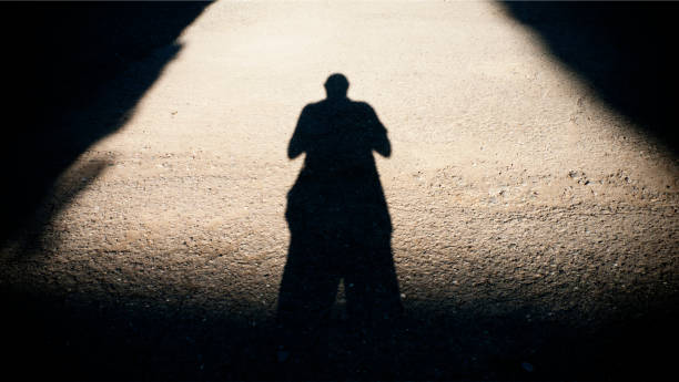 istock Shadow of a man on the road. 1167588291
