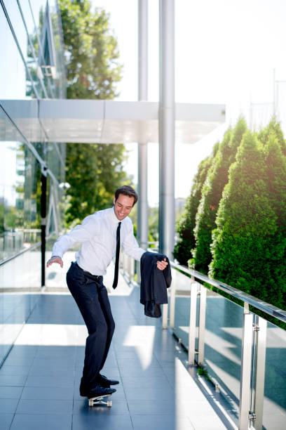 istock Handsome businessman riding skateboard 1167588596