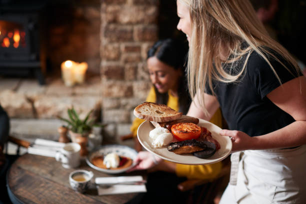 el primer plano de la camarera que trabaja en el pub inglés tradicional que sirve el desayuno a los huéspedes - english pub fotografías e imágenes de stock