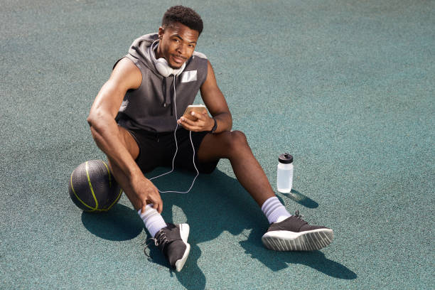 istock Handsome African Sportsman Using Smartphone Outdoors 1167592519
