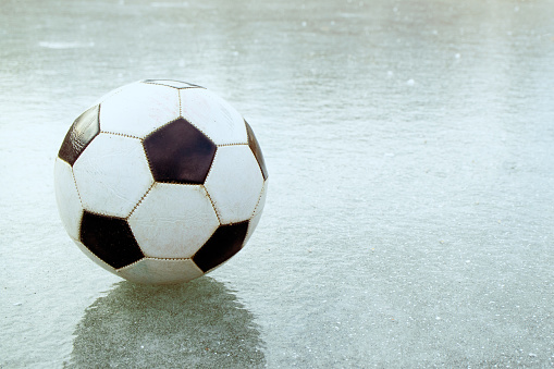 on the thin ice is a football that flew off the field the ball on the frozen pond
