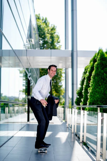 istock Handsome businessman riding skateboard 1167592817