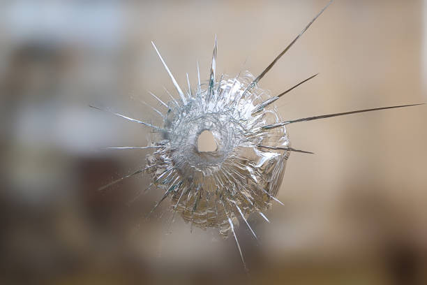 istock crack and split on the glass from a shot at it, the background is blurred brown 1167592887
