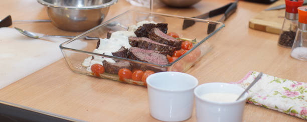 istock Ready-made dish with beef tenderloin, cherry tomatoes and sauce on a table in a glass patch 1167594833