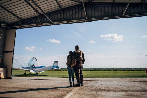 istock Father pilot and daughter looking at airplane 1167595205