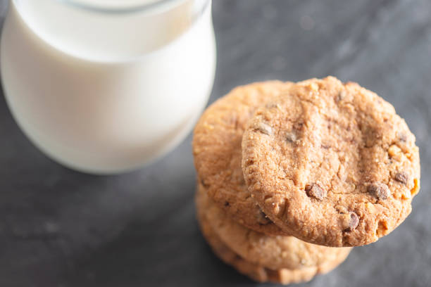 Close-up of milk bottle and cookies on table.
