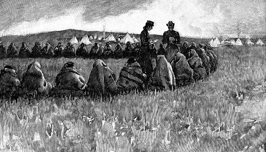 Christian missionaries talking to a tribe of Sioux First Nations people in South Dakota, USA. Vintage etching circa late 19th century.