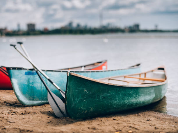 City panorama of downtown Toronto, view off the Lake Ontario. Wooden canoes pared on the shore in the foreground. Selective focus achieved with tilt and shift lens, applying maximum amount of tilt.