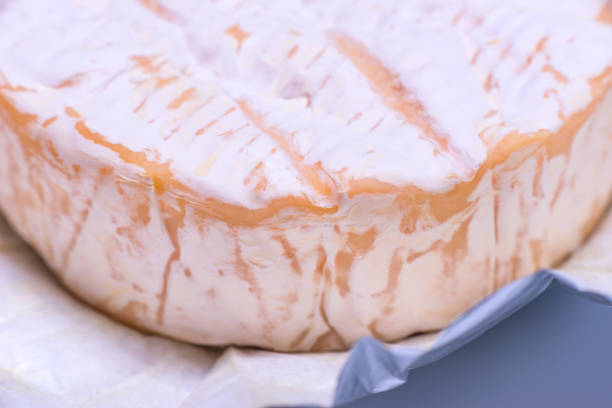 Camembert cheese close-up wrapped in foil.