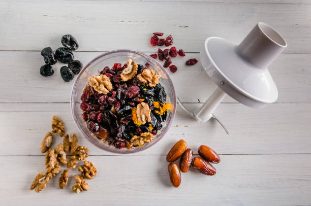 ingredients for energy balls in a blender on white background with copy space