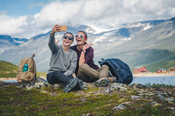 dos hermosas novias jóvenes viajan juntas en noruega, aventura, senderismo, concepto de estilo de vida - noruega fotos fotografías e imágenes de stock