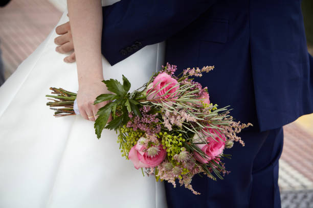 bride and groom hugging and holding a bouquet of flowers - haute couture beautiful smoking beauty imagens e fotografias de stock