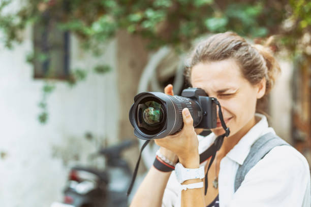 istock Beautiful young woman with a camera in her hands, professional at work 1167608429