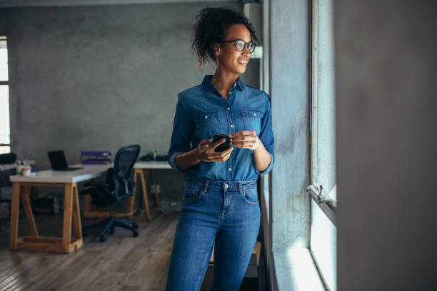 istock Woman looking out of a window in office 1167612657