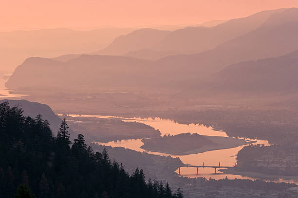 Dramatic sunset over Thompson River, distant hazy hills, Kamloops  kamloops stock pictures, royalty-free photos & images