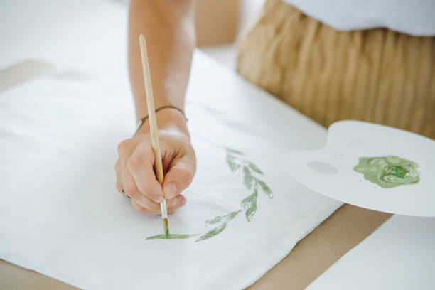 istock close-up hands paint with a brush a floral ornament 1167617541
